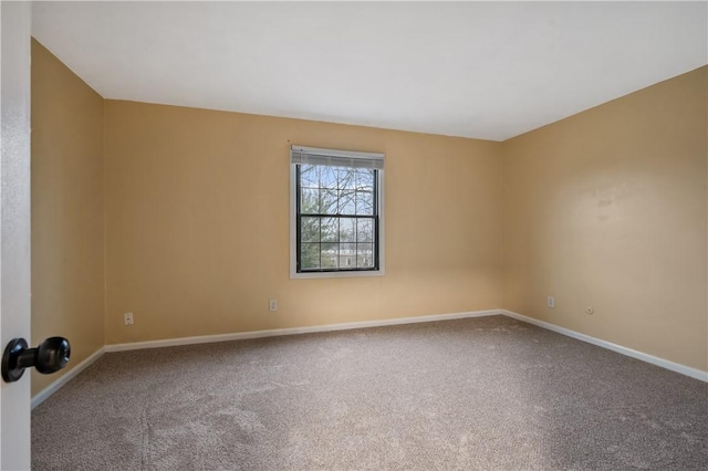 carpeted empty room with baseboards