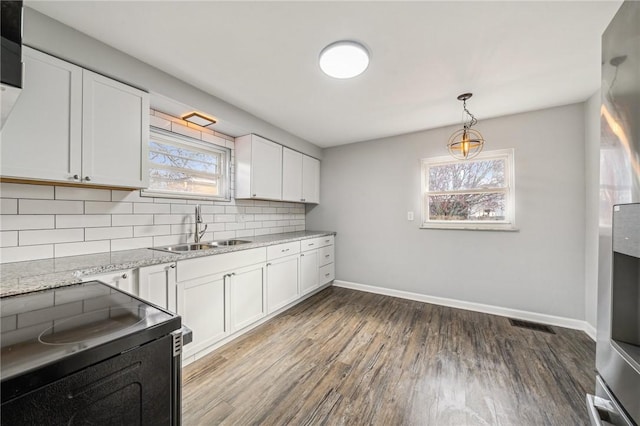 kitchen with white cabinetry, dark wood-type flooring, a healthy amount of sunlight, and electric range oven