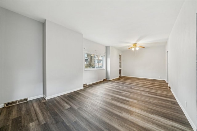 empty room with ceiling fan and dark hardwood / wood-style flooring