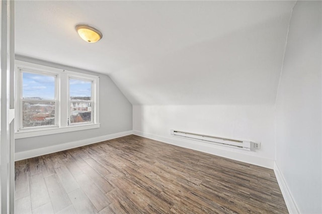 bonus room with hardwood / wood-style flooring, vaulted ceiling, and a baseboard heating unit