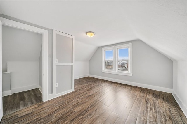 bonus room with dark hardwood / wood-style flooring and lofted ceiling