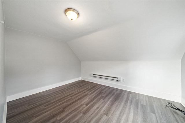 additional living space featuring wood-type flooring, lofted ceiling, and a baseboard heating unit