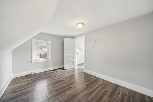 bonus room featuring dark hardwood / wood-style floors and vaulted ceiling