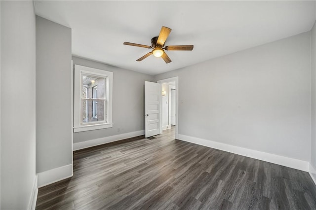 spare room with ceiling fan and dark wood-type flooring