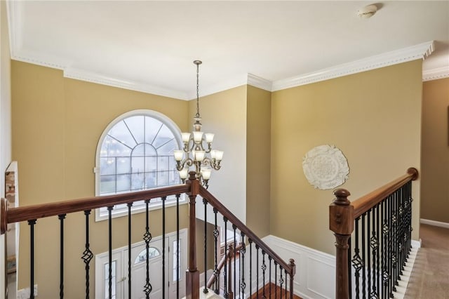 staircase featuring ornamental molding, carpet floors, and a notable chandelier