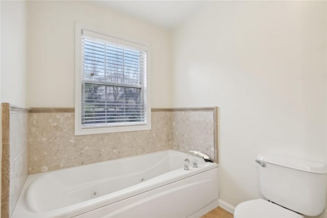 bathroom featuring toilet and a tub to relax in