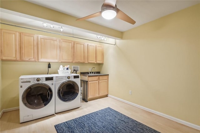 laundry area with ceiling fan, sink, cabinets, washer and dryer, and light wood-type flooring