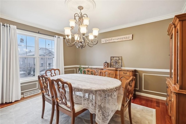 dining area featuring a notable chandelier, crown molding, and dark wood-type flooring