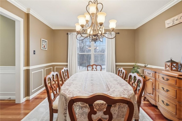 dining area with an inviting chandelier, light hardwood / wood-style flooring, and ornamental molding