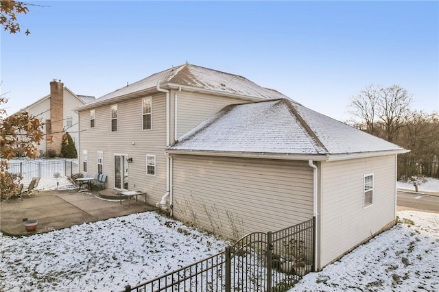 view of snow covered rear of property