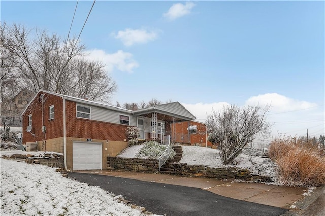 view of front of house featuring covered porch, central AC unit, and a garage