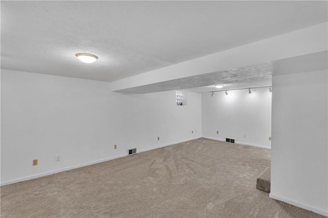 basement featuring carpet floors and a textured ceiling