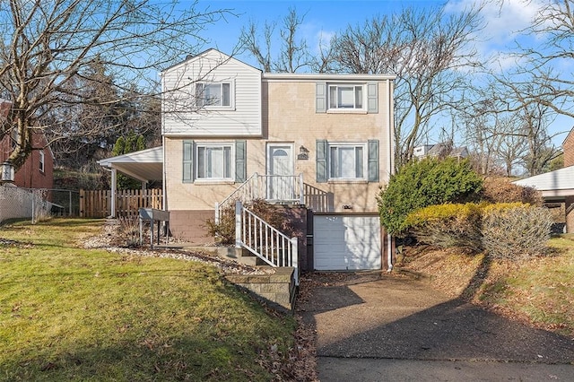 view of front of home featuring a front yard, driveway, fence, and an attached garage