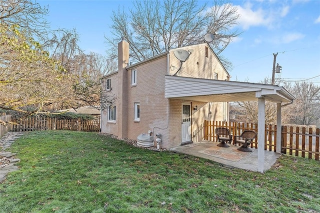 back of house with a patio area and a lawn