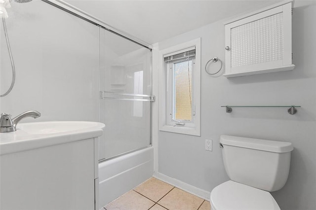 full bath with vanity, baseboards, tile patterned floors, toilet, and bath / shower combo with glass door