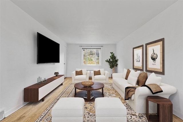 living area with light wood-style floors, baseboards, and visible vents