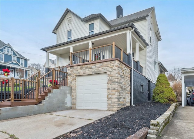 520 Washington St, Bentleyville, PA 15314 - view of front of home with an attached garage, covered porch, a chimney, concrete driveway, and stone siding