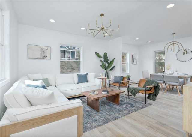 living room with light hardwood / wood-style flooring and a notable chandelier