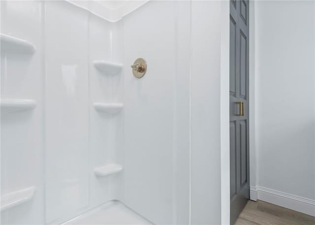 bathroom featuring hardwood / wood-style flooring and walk in shower