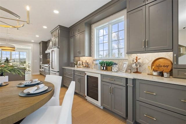 kitchen with gray cabinets, a healthy amount of sunlight, and beverage cooler