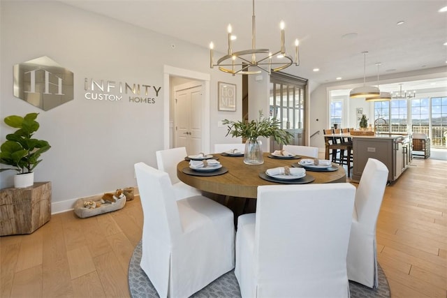 dining space featuring light wood-type flooring and an inviting chandelier