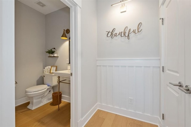 bathroom featuring hardwood / wood-style floors and toilet