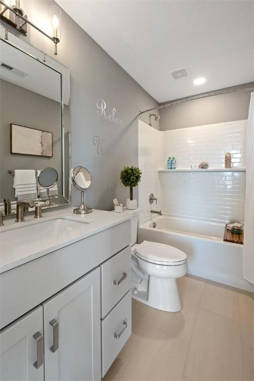 full bathroom with tile patterned flooring, vanity, toilet, and tiled shower / bath