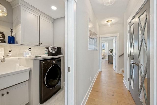 clothes washing area featuring light hardwood / wood-style floors and washer / clothes dryer