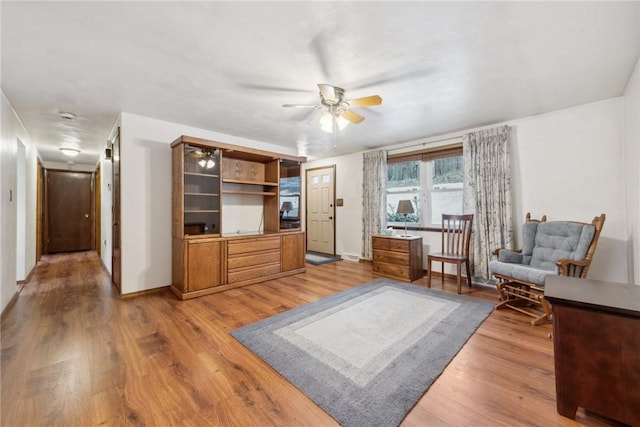 living area featuring hardwood / wood-style floors and ceiling fan