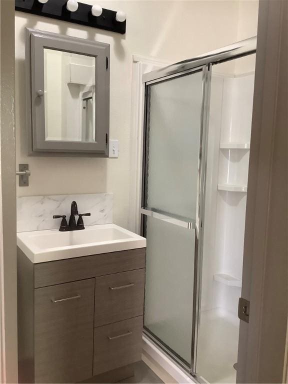 bathroom featuring vanity and a shower with door