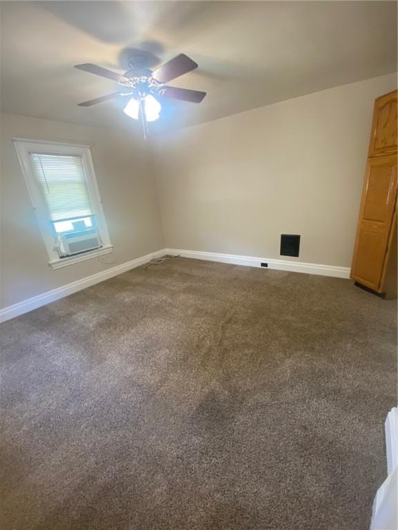 carpeted empty room featuring ceiling fan and cooling unit