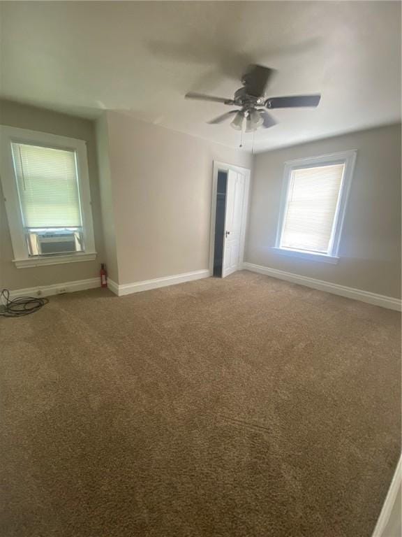 spare room featuring carpet, cooling unit, and ceiling fan