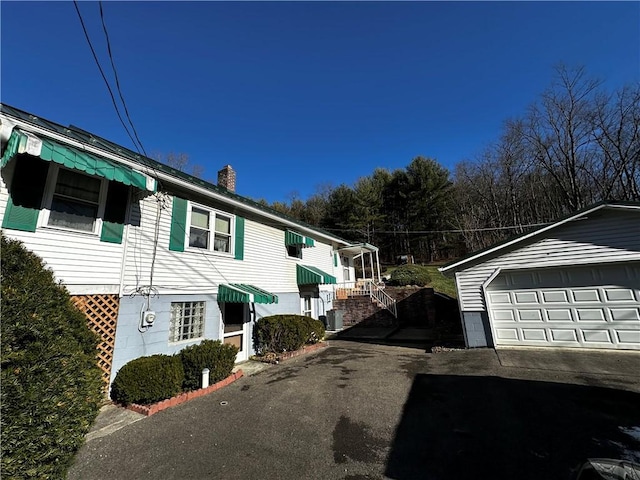 view of home's exterior featuring an outdoor structure and a garage