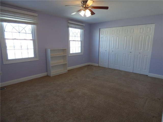 unfurnished bedroom featuring ceiling fan and dark colored carpet