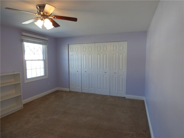 unfurnished bedroom featuring ceiling fan and dark colored carpet