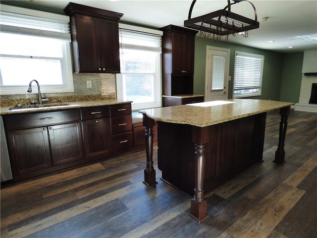 kitchen featuring a kitchen bar, dark hardwood / wood-style flooring, sink, and a center island