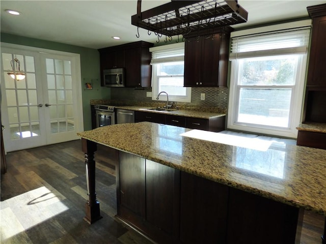 kitchen featuring french doors, sink, light stone counters, dark hardwood / wood-style floors, and appliances with stainless steel finishes