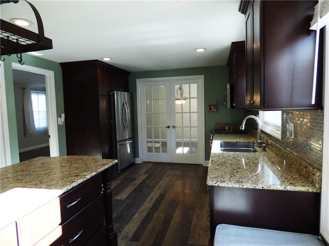 kitchen featuring french doors, sink, dark hardwood / wood-style floors, appliances with stainless steel finishes, and light stone counters