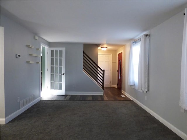 spare room featuring dark colored carpet