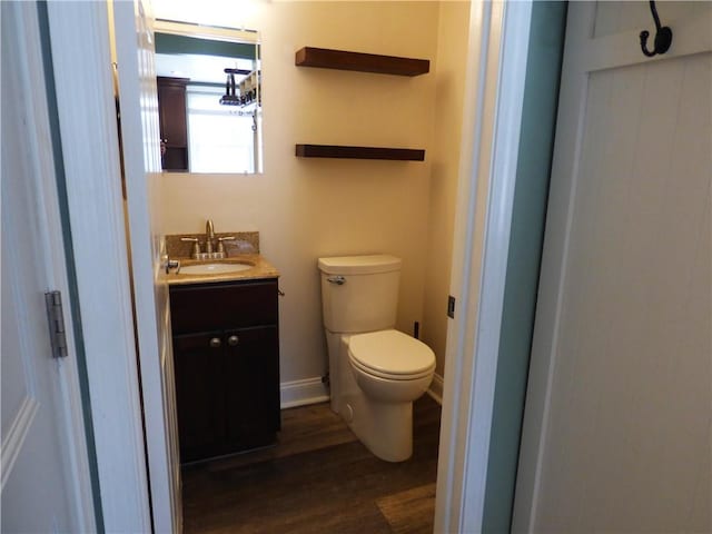 bathroom with hardwood / wood-style flooring, vanity, and toilet