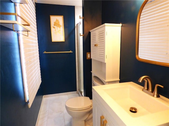 bathroom with vanity, toilet, and a shower with door