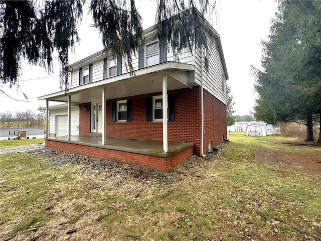 view of front of house with a garage, covered porch, and a front yard