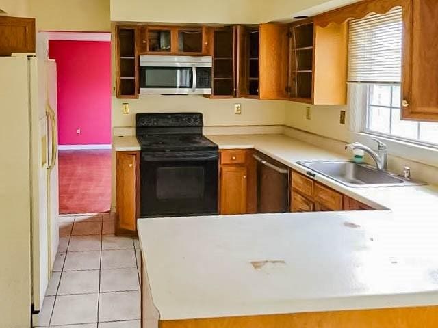 kitchen with sink, light tile patterned flooring, and appliances with stainless steel finishes