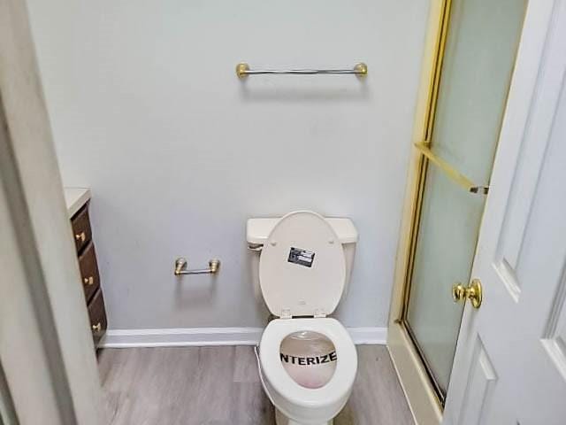 bathroom with wood-type flooring, vanity, and walk in shower