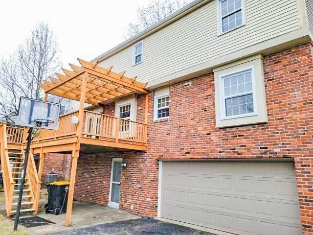 rear view of house featuring a deck and a pergola