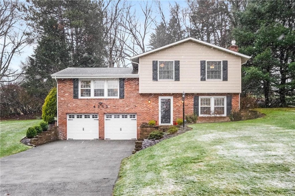 tri-level home with a garage and a front yard