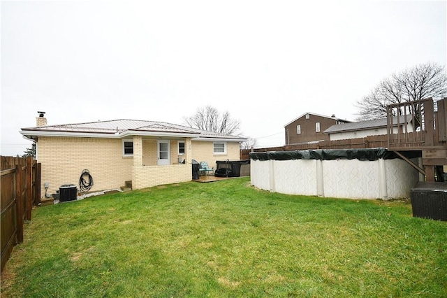 view of yard featuring central AC and a covered pool