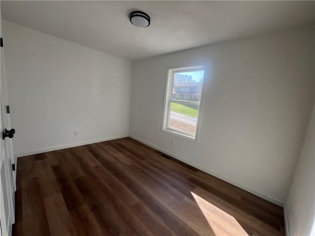 spare room with dark wood-type flooring