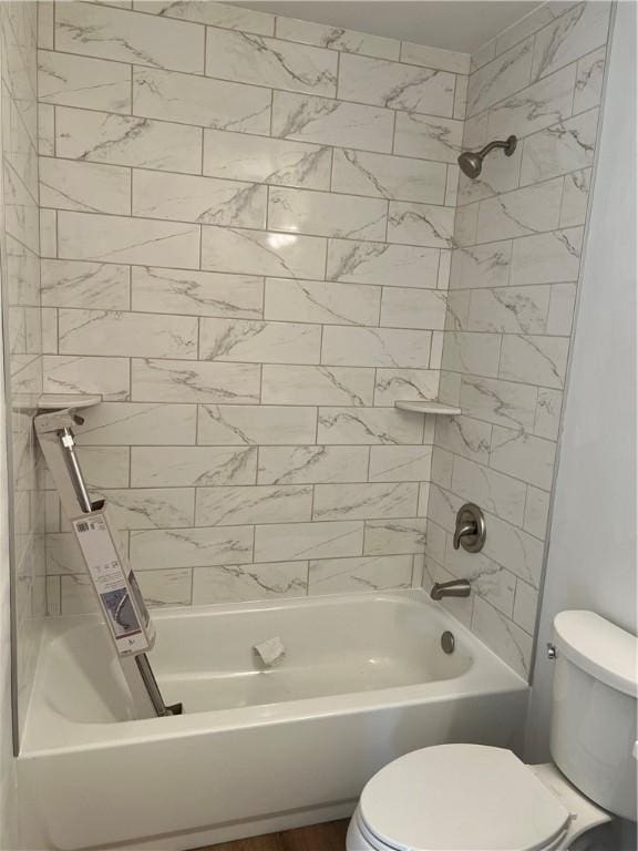 bathroom with tiled shower / bath combo and toilet