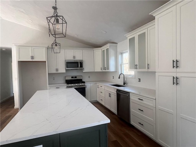 kitchen with stainless steel appliances, a center island, sink, and white cabinets